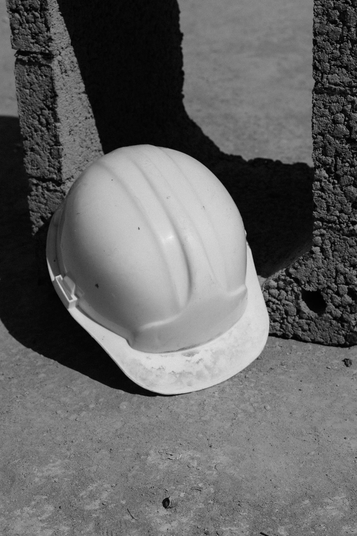 A hard hat resting against concrete blocks on site